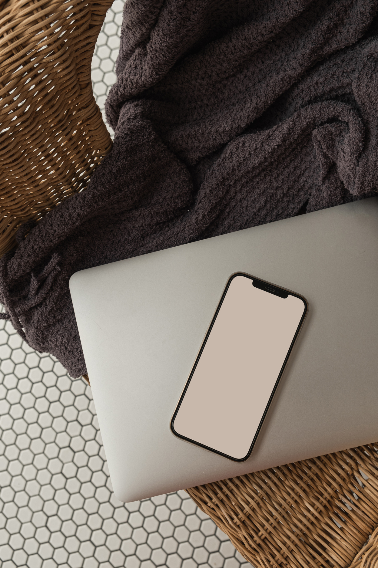 Smartphone and Laptop on a Wicker Chair with Blanket